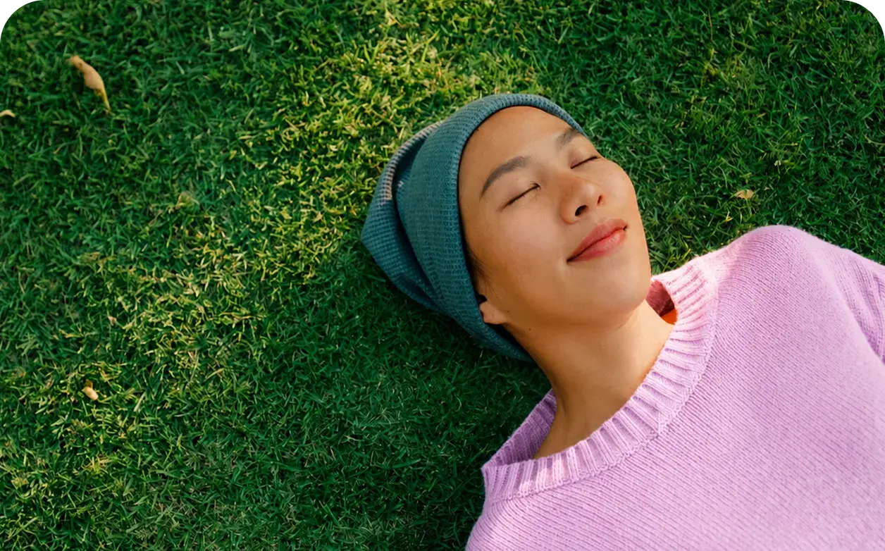 Person resting on grass, representing oncology care and support during cancer treatment.