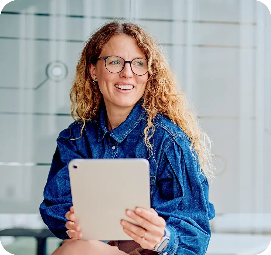 Professional holding a tablet, representing pharmacy benefit management and cost review.